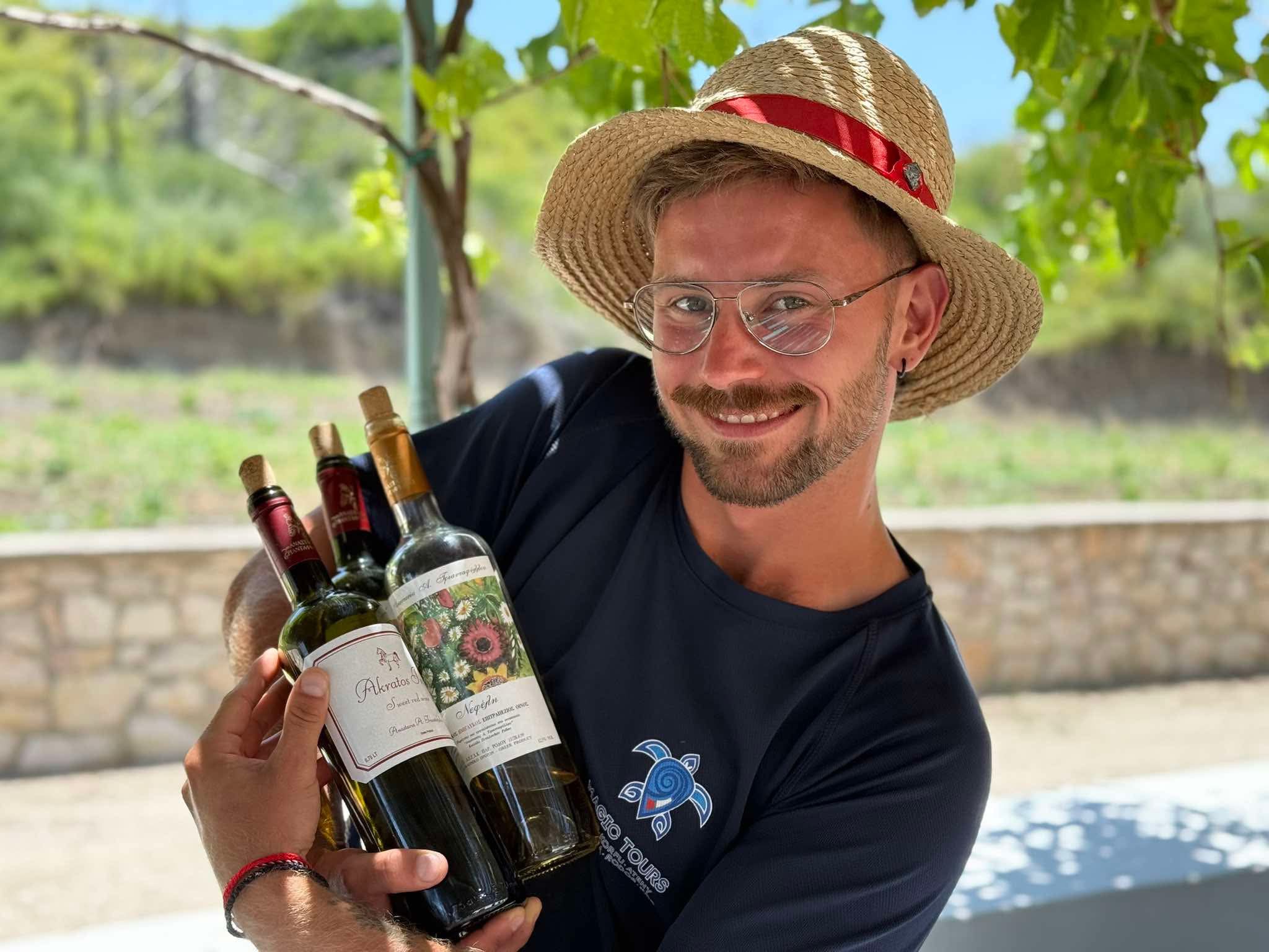 Wizyta w winiarni Rodos Tajemnice, polski przewodnik trzymające butelkę lokalnego produktu, Rodos, Grecja, wakacje na Rodos