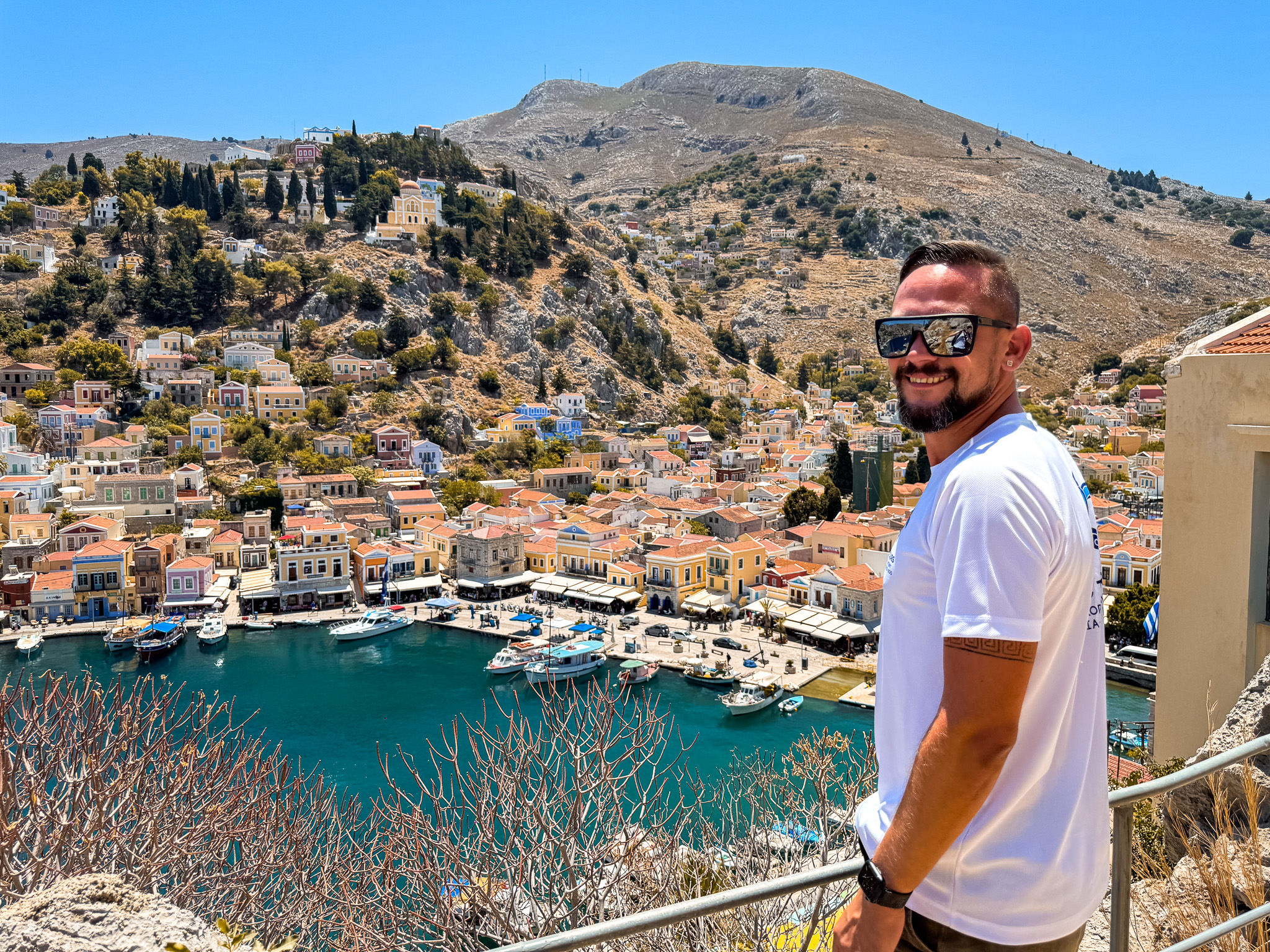 Przewodnik Magic Tours z widokiem na kolorowy port Symi podczas wycieczki z polskim przewodnikiem