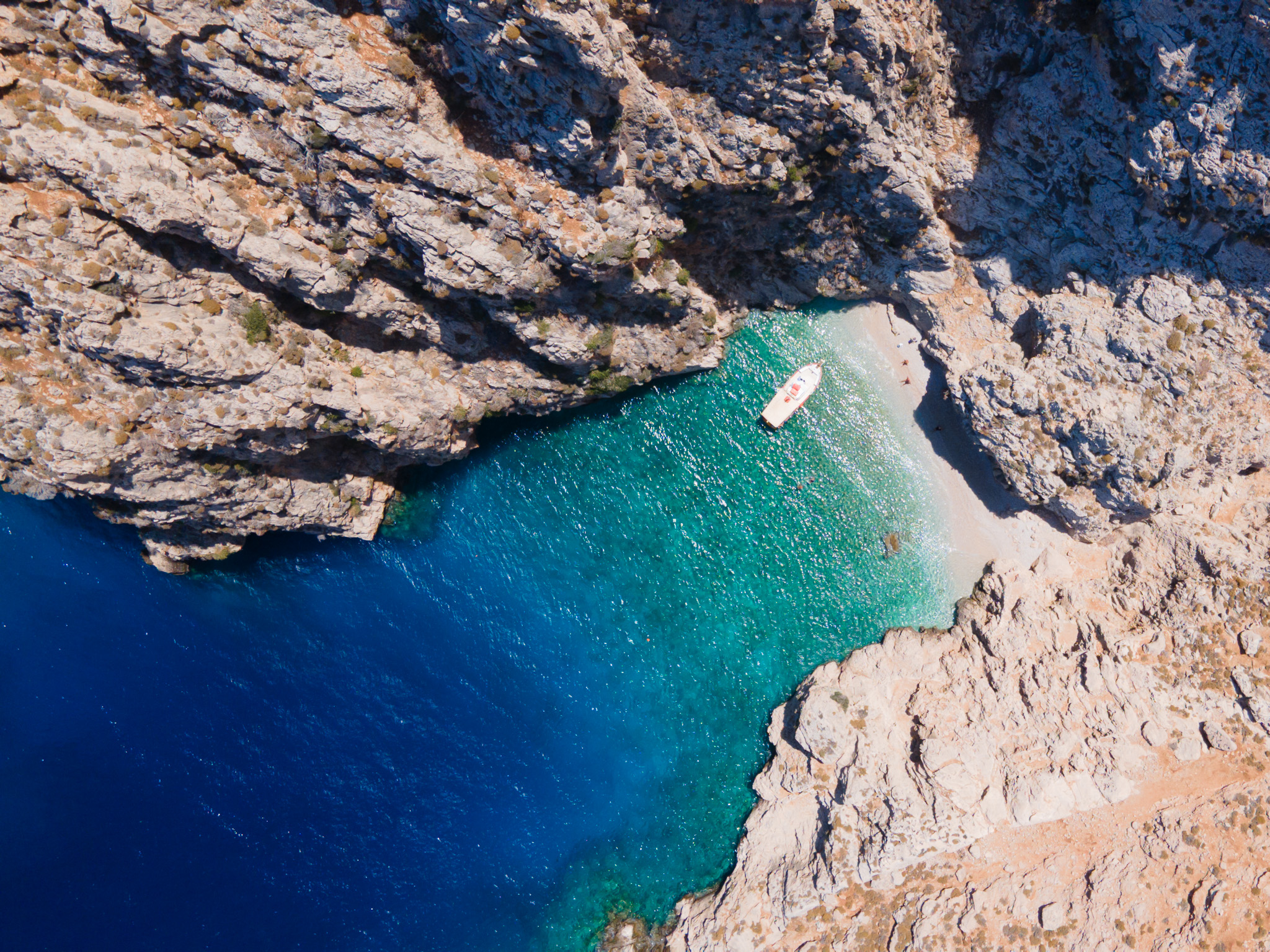 Plaża Areta na Chalki widziana z drona z turkusową wodą i łodzią