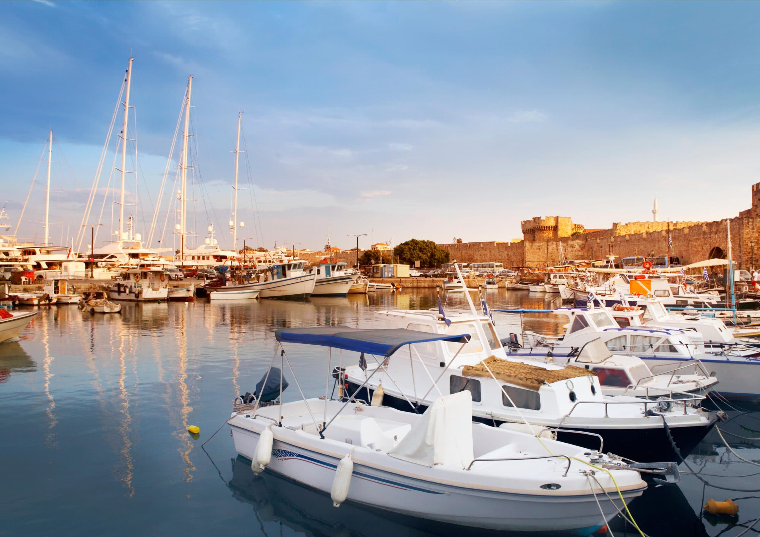 Powrót do portu w Rodos widok na port Mandraki w Rodos na tle zachodzącego słońca - Rodos, Grecja